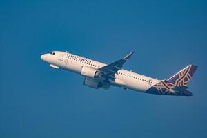 New Delhi, India, December 25 2023 - Vistara Airbus A320 neo take off from Indra Gandhi International Airport Delhi, Vistara domestic aeroplane flying in the blue sky during day time photo