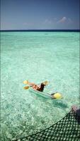 Attractive girl in the Maldives resting on a kayak. vertical footage video