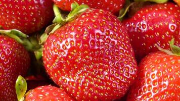 Slow motion rotation of juicy red ripe organic strawberries. Strawberry background. Top view, Rotation, Zoom out video