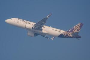 New Delhi, India, December 25 2023 - Vistara Airbus A320 neo take off from Indra Gandhi International Airport Delhi, Vistara domestic aeroplane flying in the blue sky during day time photo