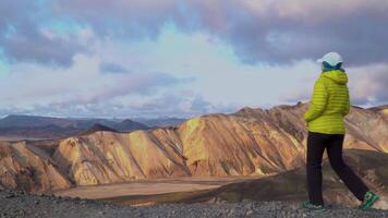 IJsland reizen toerist genieten van visie van natuur landschap landmannalaugar natuur. meisje buitenshuis door toerist bestemming mijlpaal attractie. 4k video