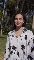 Young brunette girl on the background of palm trees in a dress. video