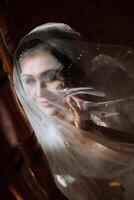 Artistic photo of a bride under a veil in the morning in a boudoir style under incredible sunlight. Wedding.