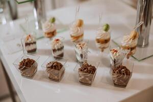 almendra galletas y varios dulce pasteles para un Boda banquete. un delicioso recepción, un lujoso ceremonia. mesa con dulces y postres delicioso vistoso francés postres en un plato o mesa. foto