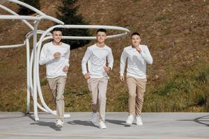 friendship, movement, action, freedom and people concept - group of three happy teenagers or school friends running forward and having fun outdoors on the background of a beautiful place. photo