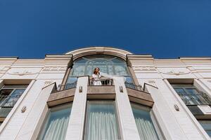 the bride on the balcony of the hotel in a white robe with a veil. Free space. Horizontal photo. On your wedding day photo