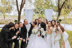 longitud total retrato de el recién casados y su amigos a el boda. el novia y novio con damas de honor y amigos de el novio son teniendo divertido y alegría a el boda. foto