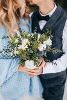 wedding bouquet in the hands of the bride and groom. Winter wedding in a rustic style. Vertical portrait. photo