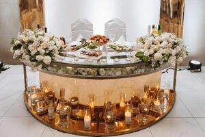 romántico mesa ajuste en un restaurante para un día festivo. Boda decoración para el recién casados a el banquete. floristería de Fresco flores y velas, boho estilo. abastecimiento para el novia y huéspedes. foto