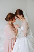 A beautiful and happy mother and her daughter, the bride, are standing next to each other. The best day for parents. Tender moments at the wedding. photo