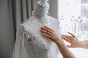 Bedroom interior with wedding dress prepared for the ceremony. A beautiful lush wedding dress on a mannequin in a hotel room. photo