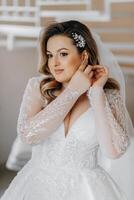 Beautiful bride in a luxurious wedding dress with a fashionable wedding hairstyle, professional make-up. Close-up portrait of young gorgeous bride in room from morning. High quality photo. photo