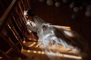 Artistic photo of a bride under a veil in the morning in a boudoir style under incredible sunlight. Wedding.