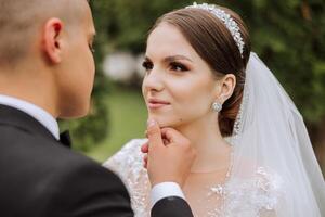 boda. amor y Pareja en jardín para boda. celebrando el ceremonia y compromiso. salvar el fecha. confianza. el novio suavemente toques el cara de el novia. Pareja en amor. Boda retrato foto