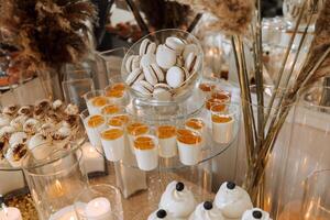 Candy bar for a wedding. Candy bar standing festive table with desserts, cupcakes and macarons. Beautiful and tasty. photo