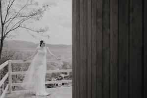 Wedding black and white portrait. The bride is posing in an elegant wedding dress. Morning of the bride. Beautiful hair and makeup photo