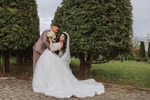 boda. amor y Pareja en jardín para boda. celebracion de ceremonia y compromiso. salvar el fecha. confianza. el novia y novio abarcar. sonrisa y amor. foto de contento y en amor novias y novios.