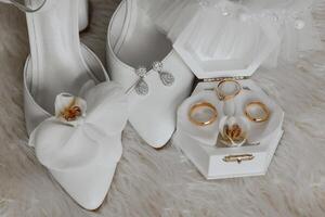 Details of the bride. Beauty is in the details. High-heeled bridal shoes. Gold wedding ring with a diamond. Perfumes. Earrings Wedding in details. photo