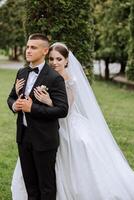 boda. amor y Pareja en jardín para boda. celebracion de ceremonia y compromiso. salvar el fecha. confianza. el novia y novio abarcar. sonrisa y amor. el novia abrazos el novio por el espalda. foto