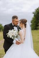 Wedding. Love and couple in garden for wedding. Celebration of ceremony and commitment. Save the date. Trust The groom embraces the bride in the mountains on the background of the forest photo