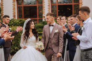 full-length portrait of the newlyweds and their friends at the wedding. The bride and groom with bridesmaids and friends of the groom are having fun and rejoicing at the wedding. photo