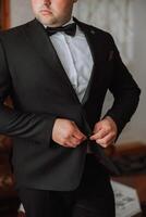 the man fastens the buttons on his jacket. The groom is preparing for the wedding ceremony. Detailed close-up photo of hands