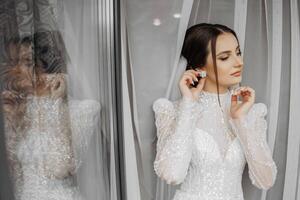 Moda retrato de un hermosa novia en un lujoso Boda vestir con cordón y cristales en un Arábica interior estilo. morena contento mujer vistiendo Boda vestir con Boda maquillaje y peinado. foto