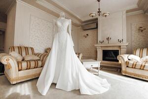 wedding dress in the interior of the hotel, prepared for the ceremony. Wedding dress with sleeves and closed shoulders photo