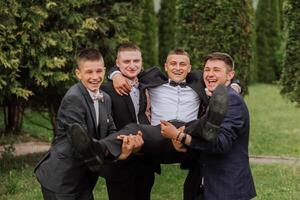 alegre, joven, energético testigos de el novio siguiente a el novio. amigos felicitar el novio. novio y su gracioso amigos teniendo divertido en el Boda día de el recién casados. foto