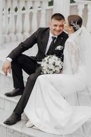 The bride and groom embrace near the Roman-style columns. An exquisite wedding photo