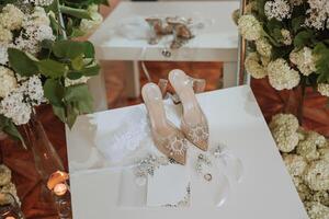 detalles de el novia. belleza es en el detalles. tacones altos nupcial zapatos. oro Boda anillo con un diamante. perfumes pendientes Boda en detalles. foto