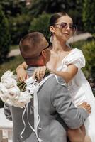 frio novia y novio teniendo divertido y vistiendo Gafas de sol al aire libre en soleado clima foto