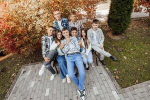 friendship, movement, action, freedom and people concept - group of happy teenagers or school friends posing and having fun outdoors against nature or forest background. photo