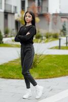 Vertical photo. Beautiful carefree young teenage girl in casual clothes. Portrait of a beautiful girl against the background of nature with a blurred background. photo