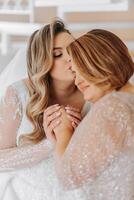 A beautiful and happy mother and her daughter, the bride, are standing next to each other. The best day for parents. Tender moments at the wedding. photo