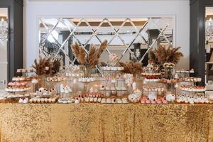 Candy bar for a wedding. Candy bar standing festive table with desserts, cupcakes and macarons. Beautiful and tasty. photo