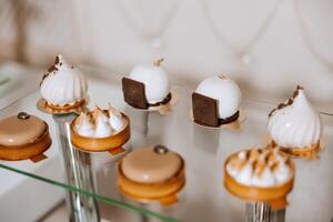 almendra galletas y varios dulce pasteles para un Boda banquete. un delicioso recepción, un lujoso ceremonia. mesa con dulces y postres delicioso vistoso francés postres en un plato o mesa. foto