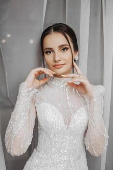 fashion portrait of a beautiful bride in a luxurious wedding dress with lace and crystals in an Arabic interior style. Brunette happy woman wearing wedding dress with wedding makeup and hairstyle. photo