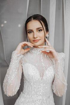 Moda retrato de un hermosa novia en un lujoso Boda vestir con cordón y cristales en un Arábica interior estilo. morena contento mujer vistiendo Boda vestir con Boda maquillaje y peinado. foto