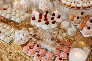 caramelo bar para un boda. caramelo bar en pie festivo mesa con postres, magdalenas y macarons hermosa y sabroso. foto