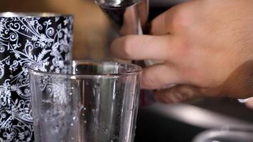 barman derramando álcool dentro uma vidro. fechar acima 4k imagens de vídeo. borrado fundo com lindo bokeh video