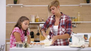 Cooking together at the kitchen. Mother and daughter having a good time video