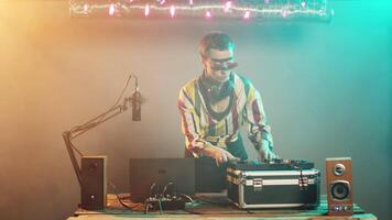 Woman artist mixing techno sounds with turntables equipment, modern musician playing disco tunes and remix at stereo electronic mixer. Performing with control keys and buttons. Tripod shot. video