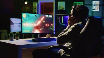 Man putting headphones on to play spaceship flying singleplayer game with overlay HUD showing health, fuel, ammo bars and minimap. Gamer immersed in gaming experience, navigating galaxy video