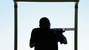 Silhouette of a shooter skeet shooting in a sports competition video