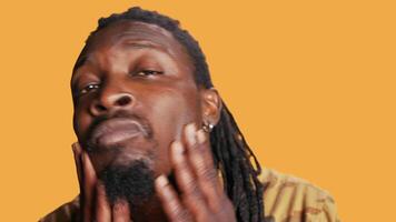 POV of african american man checking his reflection in the mirror, arranging his beard and his hair braids to look attractive and trendy. Cool person is looking at himself and smiling. Tripod shot. video