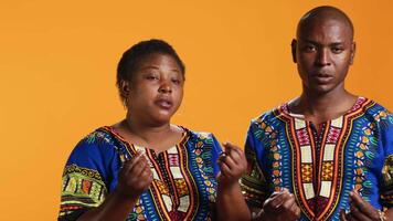 Confident african american couple asking for money with hand gesture, rubbing fingers together in order to receive cash payment. People with financial problems asking for their salary to pay loans. video