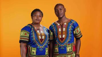 Confident ethnic couple showing stop sign in studio, raising palm and expressing their rejection. Man and woman doing refusal negative symbol, being displeased and disappointed. video