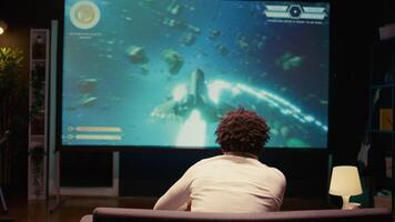 africain américain joueur recevoir gagnant écran sur ultra-large intelligent la télé après meurtre tout ennemis dans science fiction jeu. joueur victorieux dans sf jeu vidéo sur console système attaché à télévision ensemble video