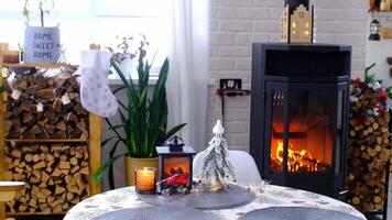 metall negro cocina, ardiente hogar hogar en blanco festivo interior de casa es decorado para Navidad y nuevo año, Navidad árbol. leña en el pila de leña, acogedor y calefacción de hogar video